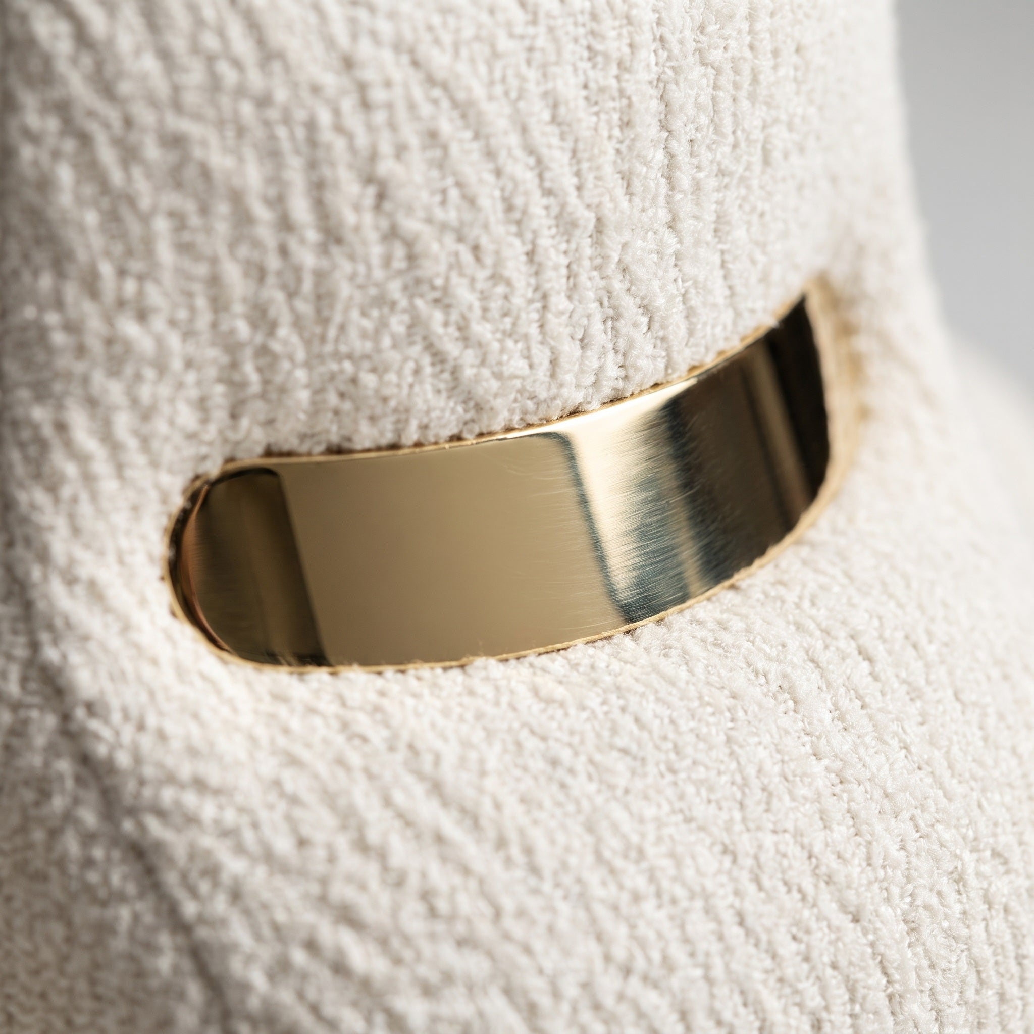 A sleek, polished gold bar embedded in the backrest mimics a visor, adding a sci-fi-inspired elegance